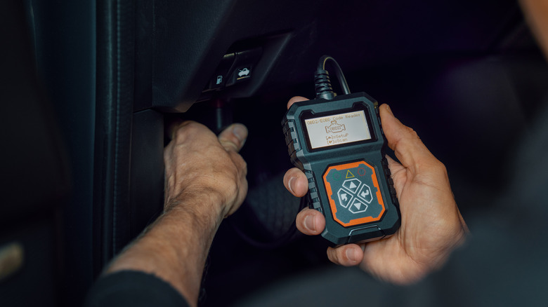 Man connecting OBD scanner in car