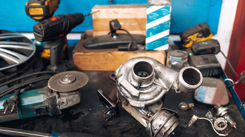 Turbocharger and related parts and tools on workbench.