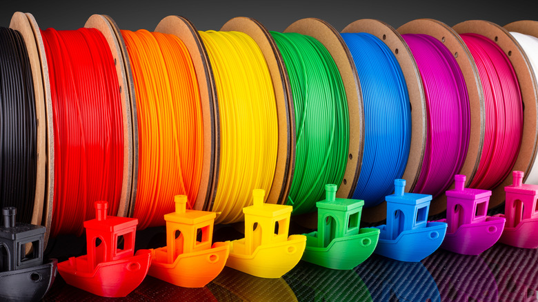 Colorful PLA filaments stand in a row with their 3D printed creations.