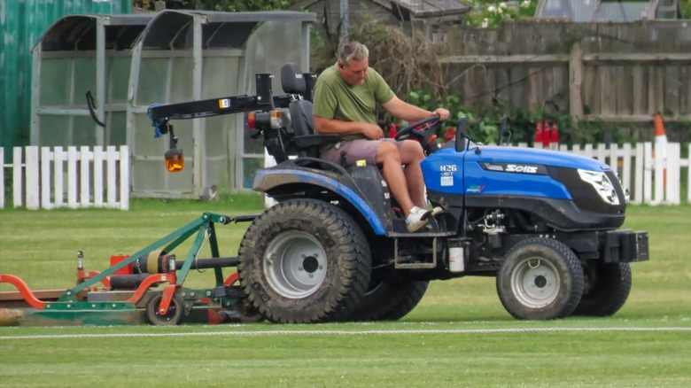 A Solis H26 compact tractor using a PTO-driven topper mower to mow.