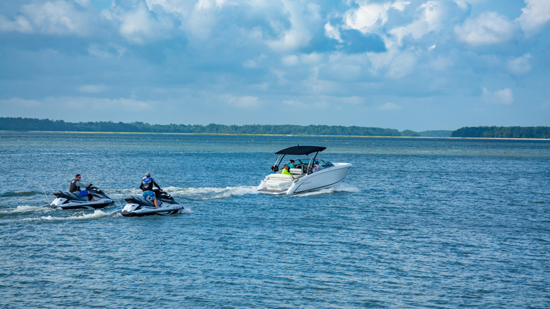 Jet skis behind boat on lake