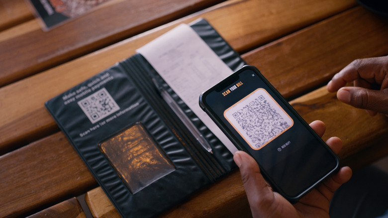 Person scanning a QR code to view bill