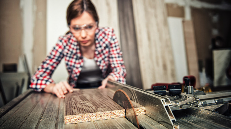A carpenter using a table saw.