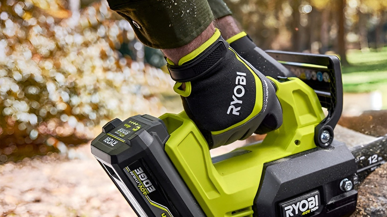 Man sawing log with Ryobi chainsaw being powered by 40V EDGE battery