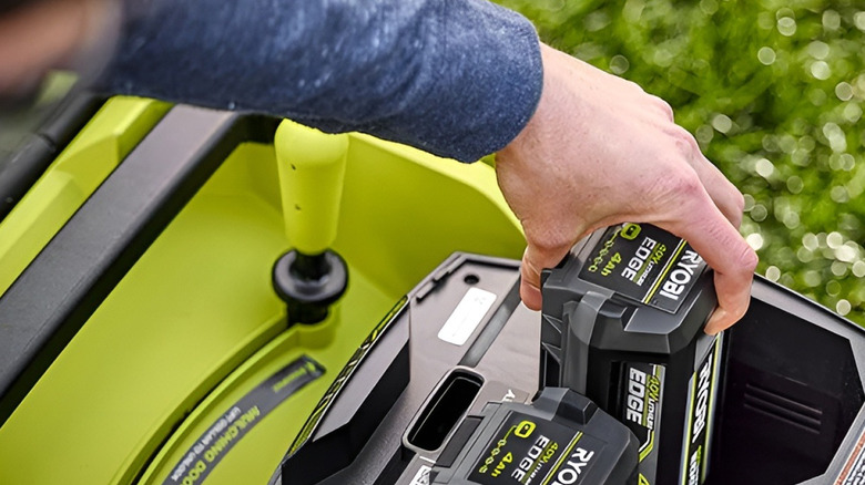 Man inserting two Ryobi Edge 40V batteries into power tool