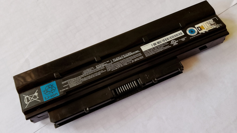 A laptop battery pack with its underside exposed, lying on a white surface