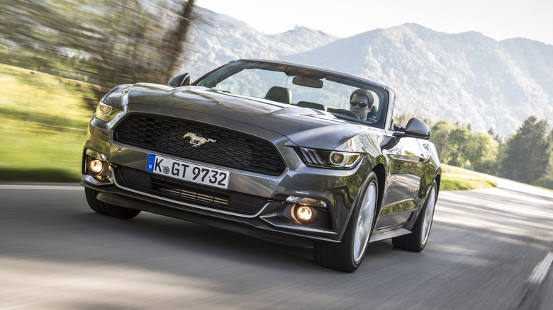 Front 3/4 view of S550 Mustang convertible in mountain setting with German license plate