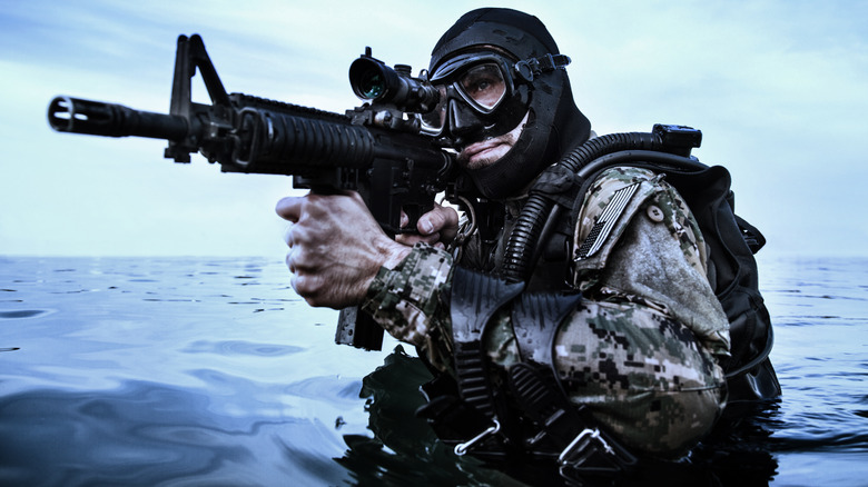 Navy SEAL frogman with complete diving gear and weapons in the water