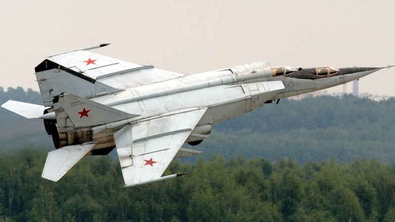 A Russian Air Force MiG-25 flying low over a forest.