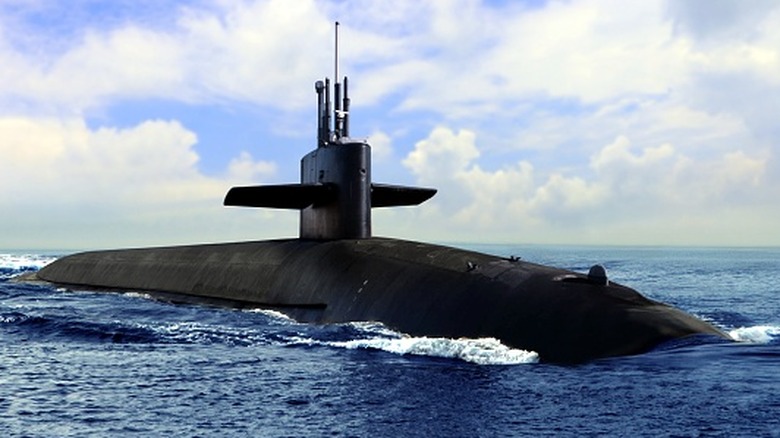 Black colored submarine partially surfaced cruising in the ocean.