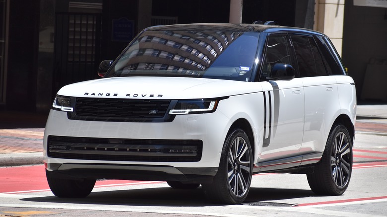 Um Range Rover branco estacionado por uma calçada