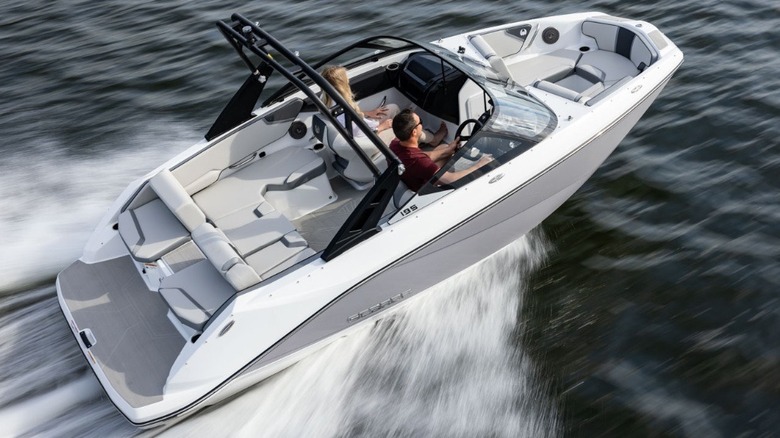 A Scarab 195 SE jet boat with a flat transom on the stern traveling at speed across the water.
