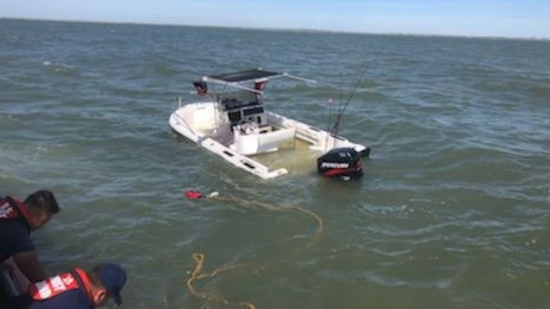 Coast Guard personnel intervening to rescue a swamped boat