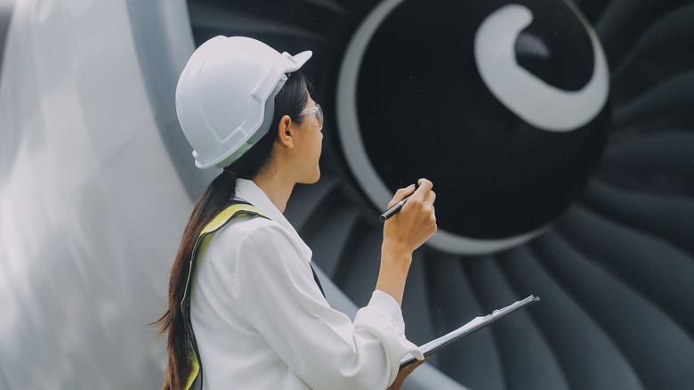 Aircraft technician inspecting engine