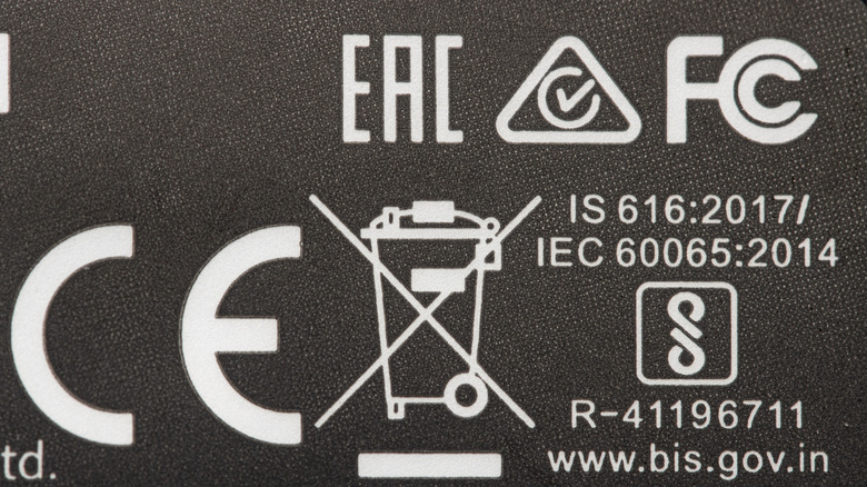Close-up shot of an electronic with a bunch of compliance marks printed on top