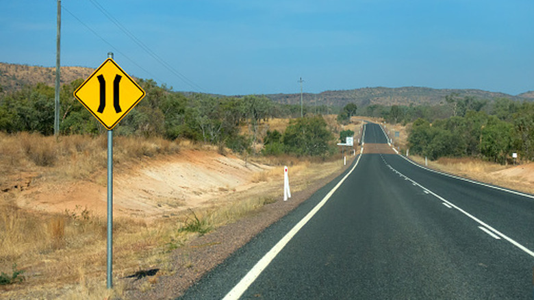 A yellow Bridge Narrows sign on the side of a road