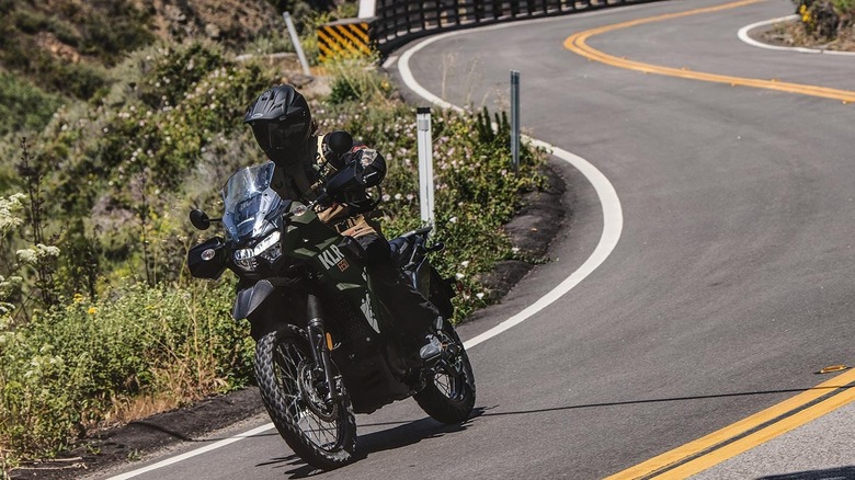 A rider on the Kawasaki KLR 650 going down a winding road.