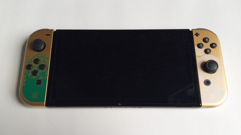 A limited edition Legend of Zelda: Tears of the Kingdom gold Nintendo Switch OLED console shown in handheld mode.