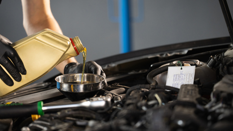 Mechanic pouring engine oil