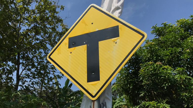 Close-up of a T-Intersection warning sign on a road