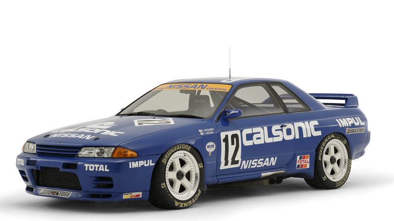 1989 Calsonic Group A Nissan Skyline GT-R R32 in race livery on white background, front-left view