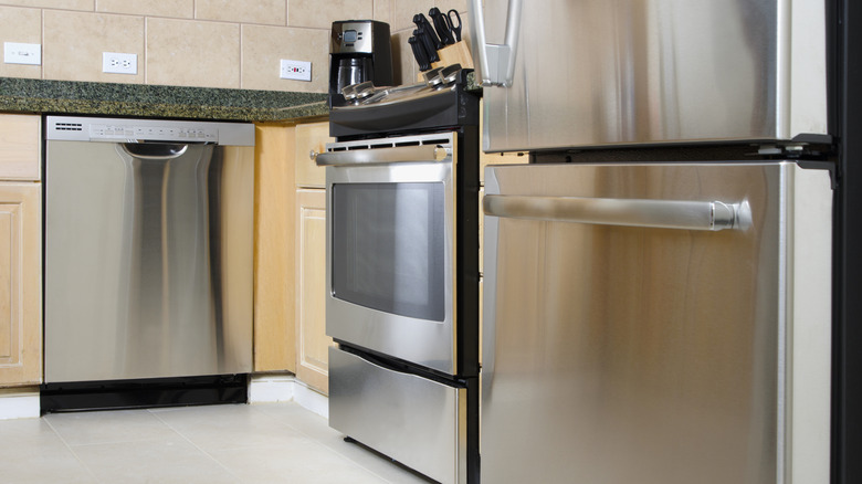 A kitchen with a stainless steel refrigerator, dishwasher, and oven.