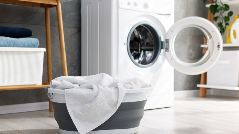 A basket of clean towels next to a washing machine.
