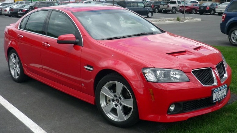 Red 2008 Pontiac G8 GT parked in an outdoor parking lot with other cars in the background