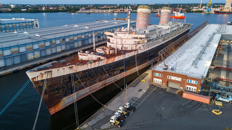 The SS United States sits docked, showcasing its impressive size and rusting hull