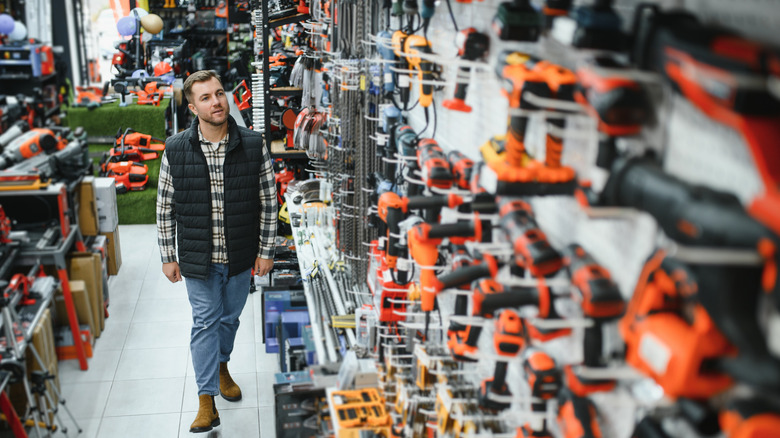A man shopping for power tools in a hardware shop