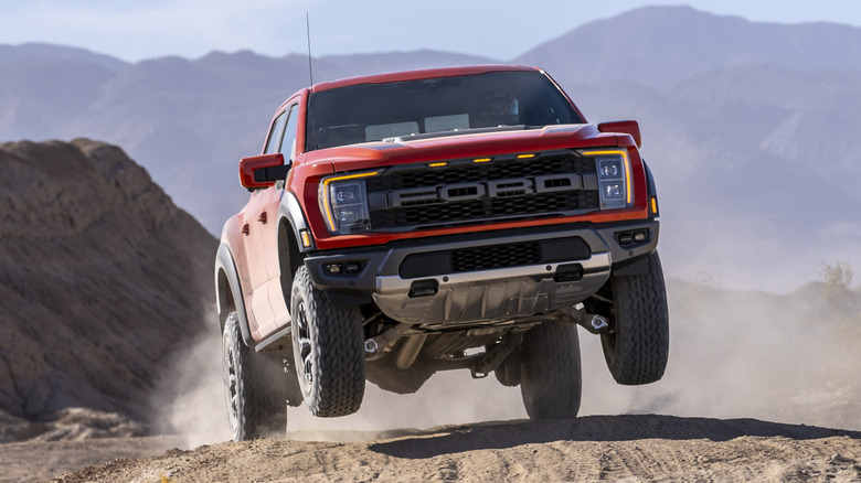 Front 3/4 view of 2021 Ford F-150 Raptor in orange on the move