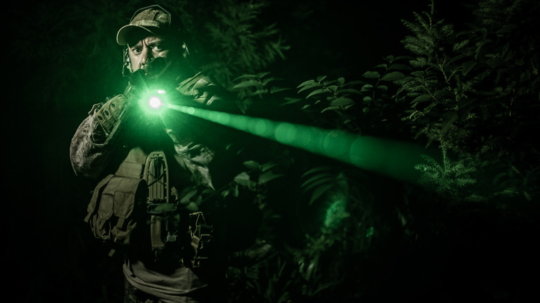 A Special Operations operator points a green laser