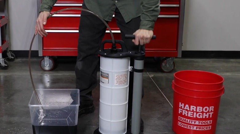 a person demonstrating how to use an oil extractor pump