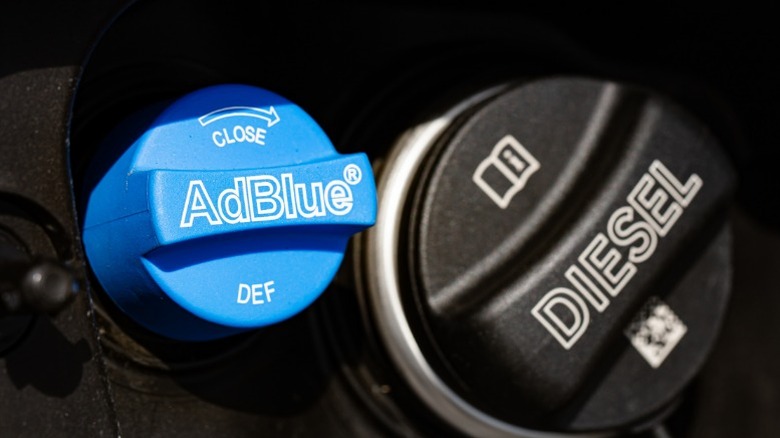 A diesel fuel cap next to a def fill cap