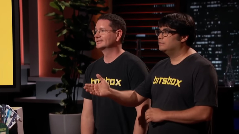 Aidan reaching out arm as Scott winces on Shark Tank