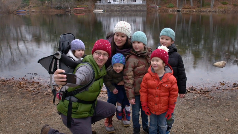 Jeff taking a selfie with his family in front of a pond