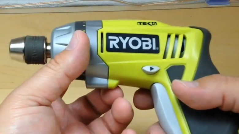 A person holding a Ryobi Tek4 screwdriver.