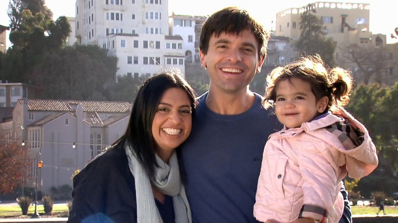 Dave and his family smiling in front of buildings