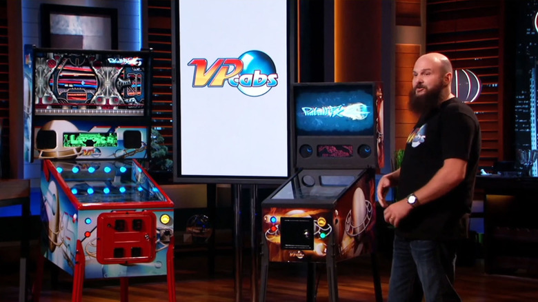 Brad Baker standing in front of virtual pinball machines on Shark Tank