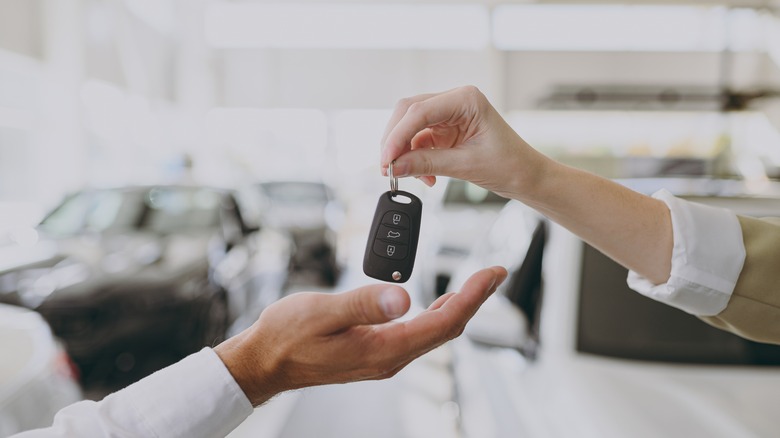 Hands exchanging car keys.