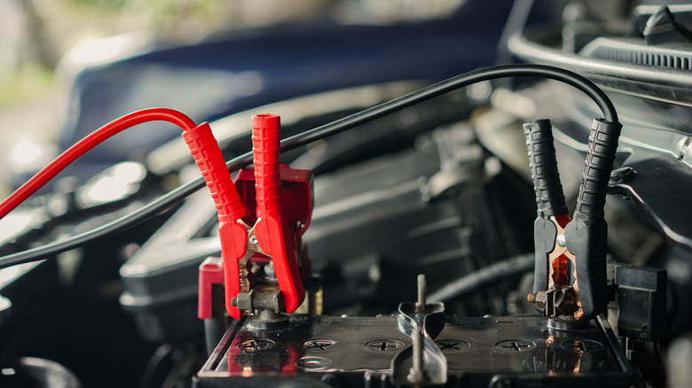 Car battery being jumped using jumper cables