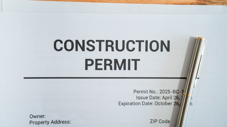 A generic construction permit with a pen on the paper