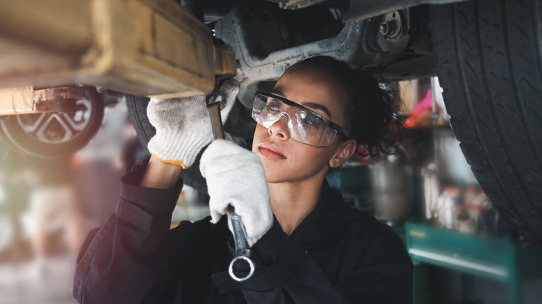 female mechanic working on suspension
