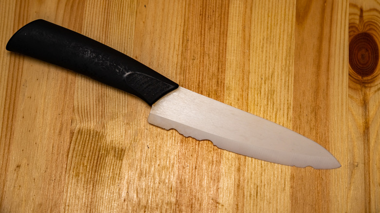 A chipped, damaged knife on a wooden surface.