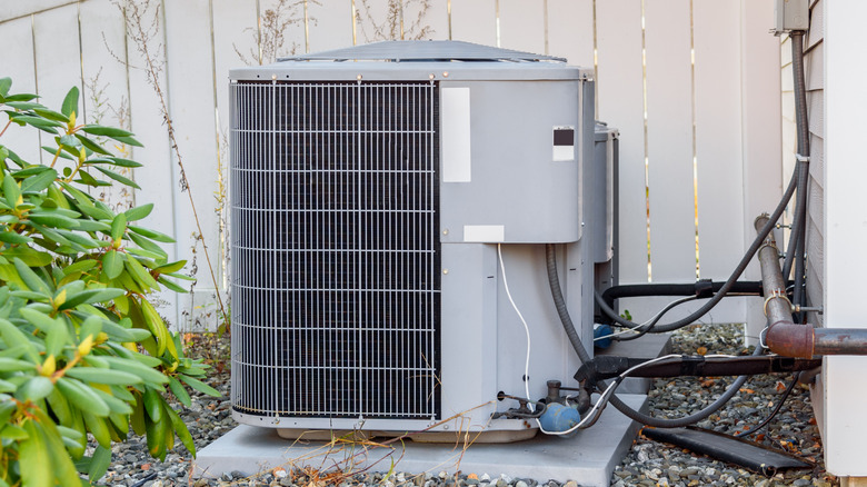 An outdoor air conditioner beside a house.
