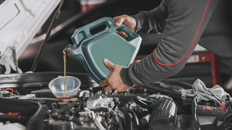 Pouring fresh engine oil into a car engine