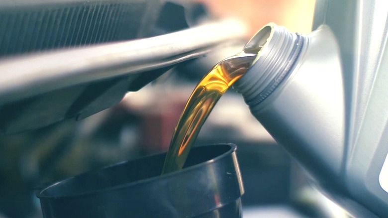 Motor oil being poured into an engine.