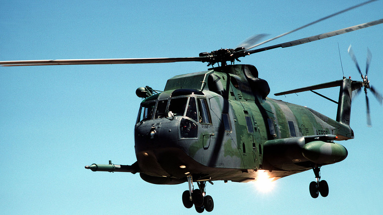Jolly Green Giant helicopter flying with blue sky behind it