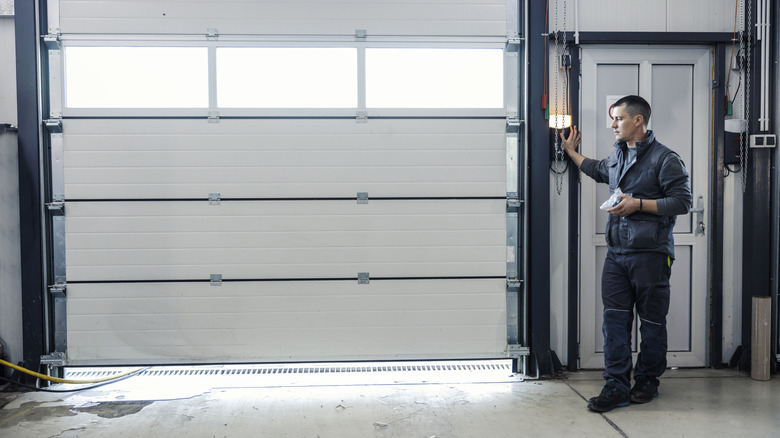 man pressing button to open garage door