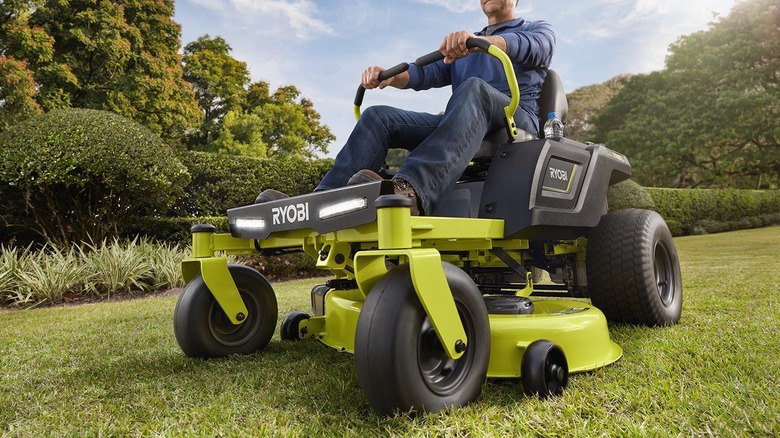 Man riding Ryobi lawn mower with foot rest